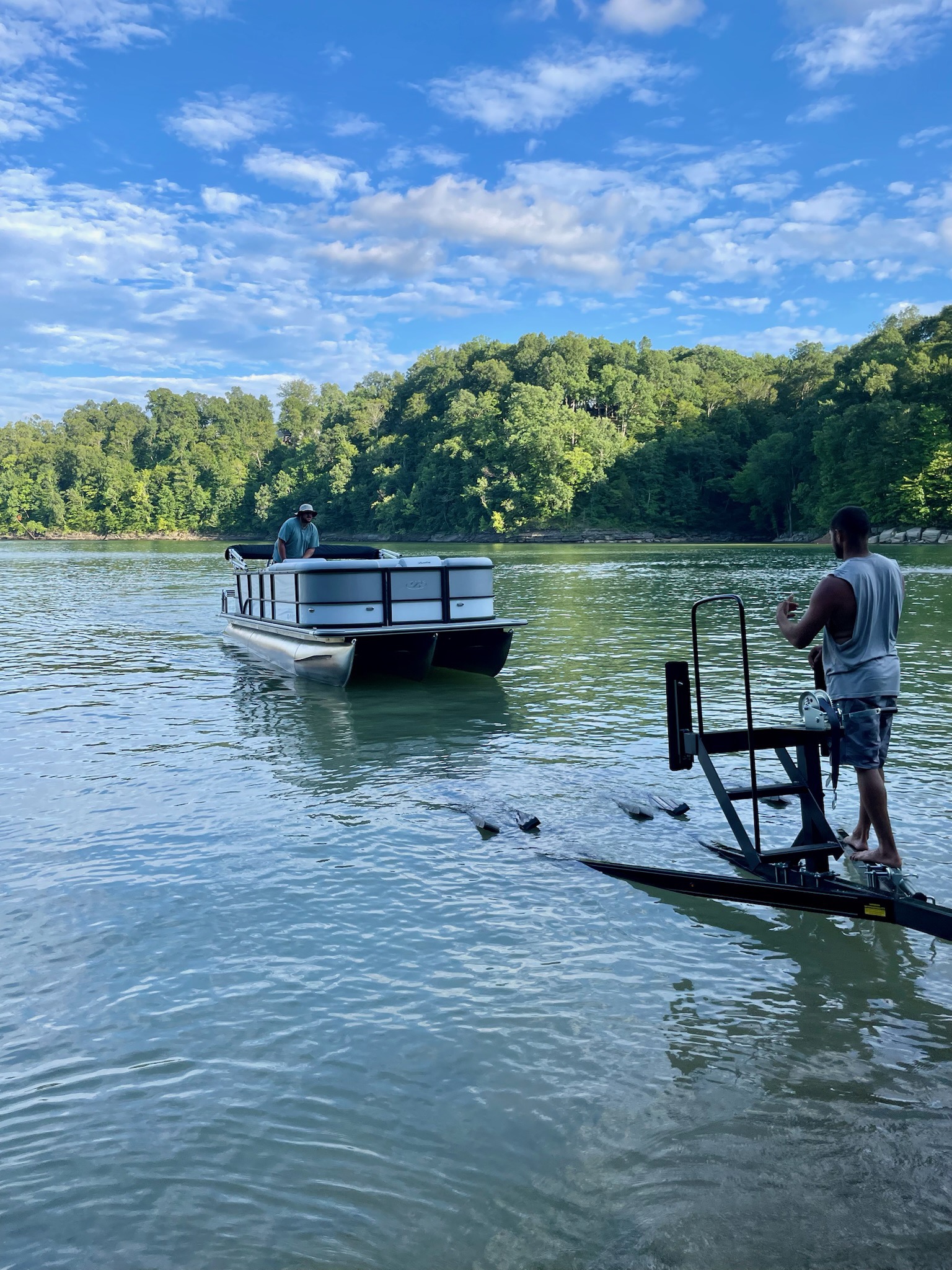 Bentley tritoon on Lake Cumberland with wooded shoreline