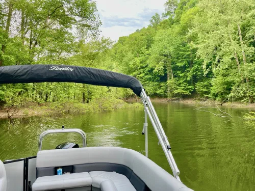 Bentley pontoon cruising a narrow wooded channel
